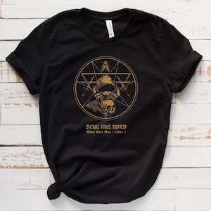 May include: Black t-shirt with a gold graphic of a skull, a pentagram, and a figure wearing a helmet. The text "BCUC AUS NORD What Once Was - Liber I" is printed below the graphic.
