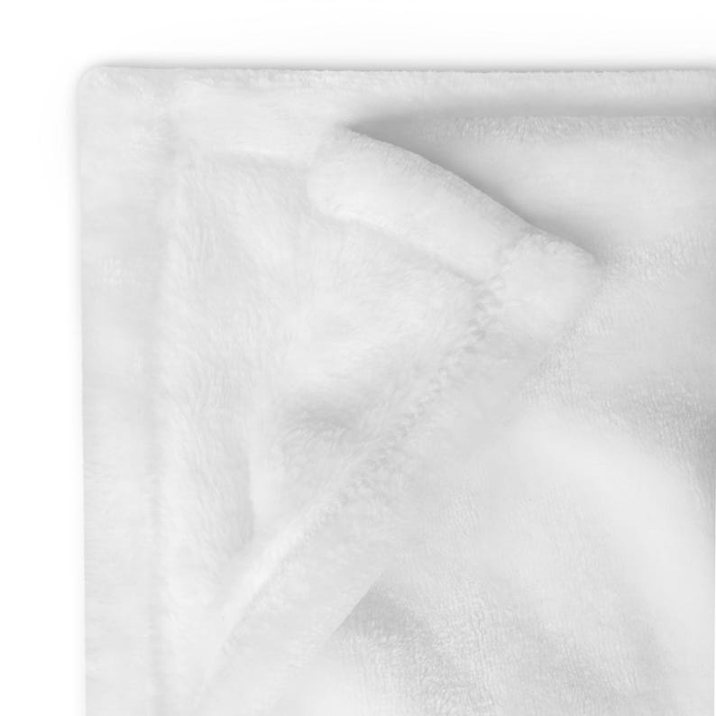 May include: A white plush blanket folded in half, showing the soft texture of the fabric.