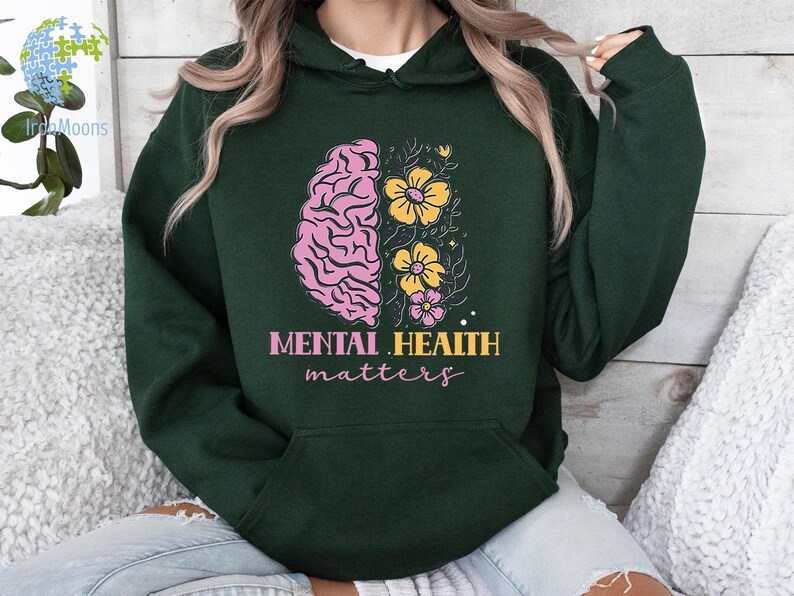 May include: A dark green hoodie with a pink and yellow brain with flowers graphic and the text "Mental Health matters".