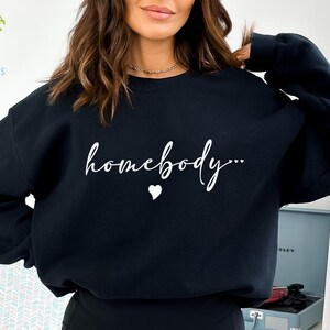 May include: Black sweatshirt with the text "homebody..." in white cursive lettering and a small white heart.