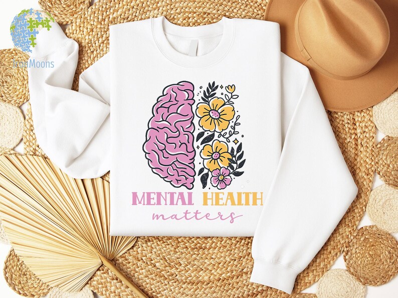 May include: White sweatshirt with a pink brain outline and yellow flowers. The text "Mental Health matters" is printed below the image.