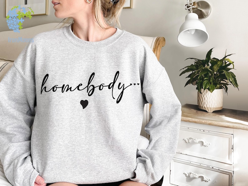 May include: Gray sweatshirt with the text "homebody..." in black cursive lettering and a small black heart.
