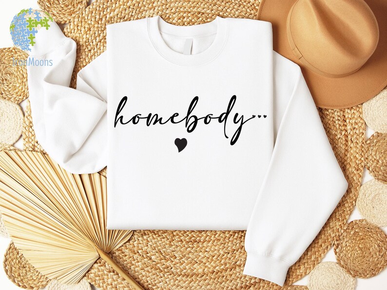 May include: White sweatshirt with the text "homebody..." in black cursive lettering and a small black heart.