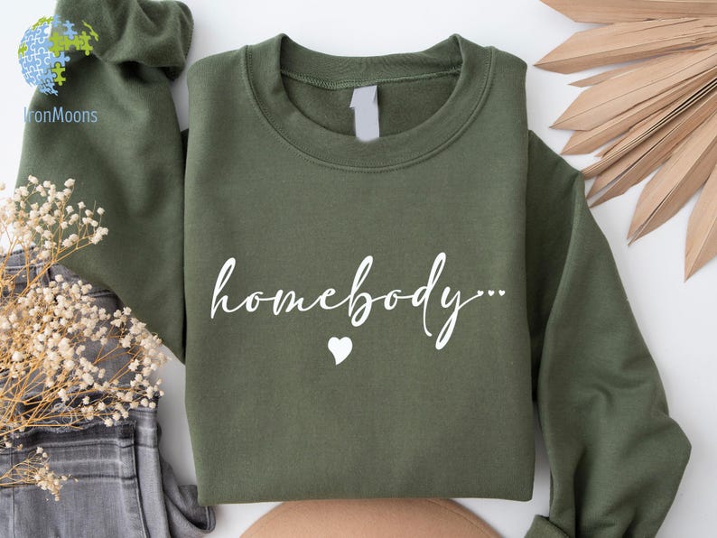 May include: A green sweatshirt with the text "homebody..." in white lettering and a small white heart.