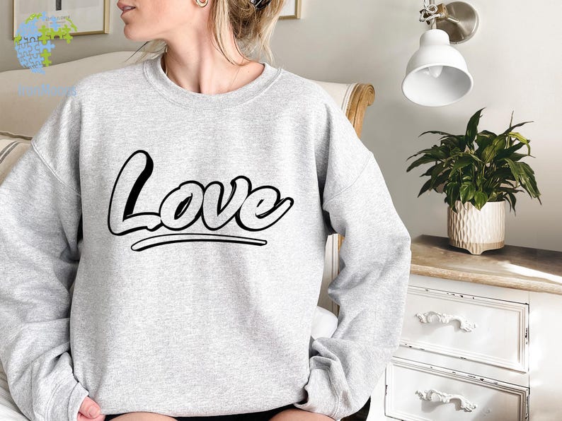 May include: A gray sweatshirt with the word "Love" printed in black stylized lettering.