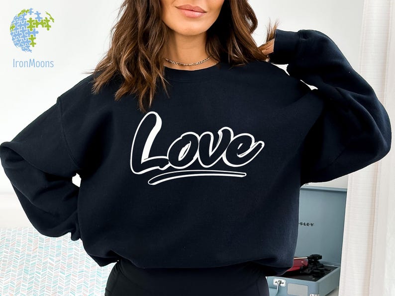 May include: A black sweatshirt with the word "Love" printed in white on the front. The word is stylized with a bold, rounded font.
