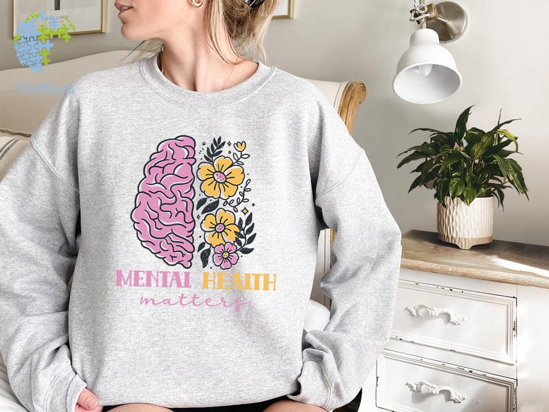 May include: A gray sweatshirt with a pink and yellow brain and flowers graphic. The text "Mental Health matters" is printed below the graphic.