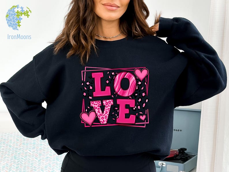 May include: Black sweatshirt with a pink "LOVE" graphic featuring leopard print and hearts.
