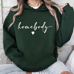May include: A dark green hoodie with a white graphic that says "homebody..." with a small heart.