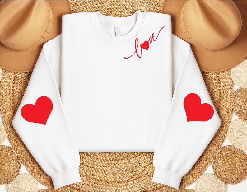 May include: White sweatshirt with red hearts on the sleeves and the word "love" with a heart on the front.