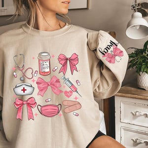 Coquette Nurse Sweatshirt, Pink Bow Nurse Sweatshirt, Girl Nurse Sweater,Softcore Nurse Graduation, Girly Nurse Birthday Gift, New Nurse Tee