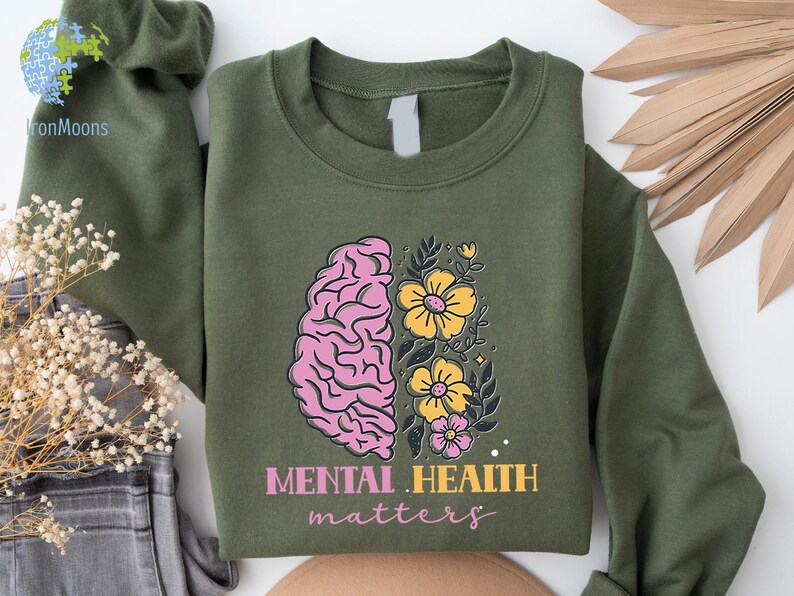 May include: Green sweatshirt with a pink and yellow brain with flowers and the text "Mental Health Matters".