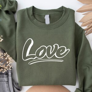 May include: A green sweatshirt with the word "Love" printed in white on the front.