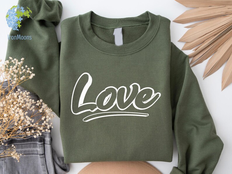 May include: A green sweatshirt with the word "Love" printed in white on the front.