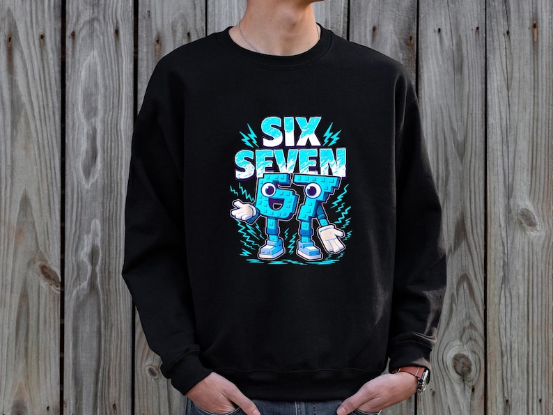 May include: Black sweatshirt with a blue graphic design. The design features the words "SIX SEVEN" in a stylized font, along with animated blue numbers with arms, legs, and shoes. The sweatshirt is made of a soft material.