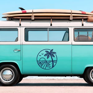 Puede incluir: Una furgoneta vintage turquesa y blanca con tablas de surf en el techo. Un diseño gráfico circular de una palmera y olas está en el lateral. La furgoneta está aparcada en una playa de arena bajo un cielo azul claro.