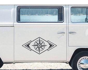 May include: A black vinyl decal featuring a central compass rose design enclosed within a diamond shape, flanked by two sets of horizontal arrowheads pointing outward, applied to the side panel of a white van.