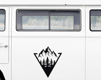 May include: Black mountain and forest graphic inside a black triangle, applied to the side of a white van. The design features a detailed mountain range above a row of stylized evergreen trees.