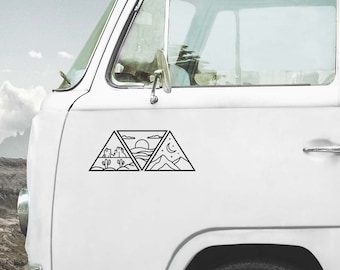 May include: A black line art decal applied to the side of a white van. The design consists of three connected triangles featuring a desert landscape with cacti, a sun setting over ocean waves, and a mountain range under a crescent moon.