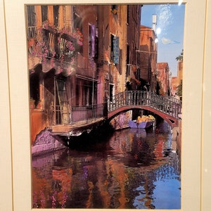 Könnte beinhalten: Ein Gemälde eines Kanals in Venedig, Italien. Der Kanal ist von bunten Gebäuden gesäumt und eine Brücke führt über das Wasser. Ein kleines Boot fährt unter der Brücke hindurch. Das Gemälde ist signiert mit "M. Roberts" und trägt den Titel "Kanal mit Reflexionen".