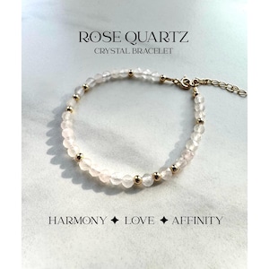 May include: A delicate rose quartz crystal bracelet with gold beads. The bracelet is made of natural stones and is designed to promote harmony, love, and affinity.  The text "ROSE QUARTZ CRYSTAL BRACELET" is displayed above the bracelet. The text "HARMONY LOVE AFFINITY" is displayed below the bracelet.