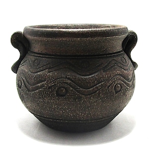 May include: A small, dark brown ceramic pot with two curved handles. The pot features a textured surface and a decorative wave pattern with circular accents around the middle. The pot is round with a wide opening.