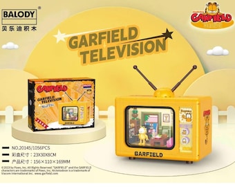 Puede incluir: Un juego de construcción de televisión con temática de Garfield de color amarillo. El juego incluye una caja con el logotipo de Garfield Television y un modelo de televisión construido. El modelo de televisión tiene antenas y una pequeña figura de Garfield en el interior. Las dimensiones de la caja son 23x30x8cm.