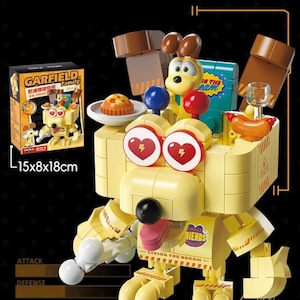 May include: A yellow Odie Vehicle toy made of building blocks, with a Garfield theme. The toy includes a box with the dimensions 15x8x18cm. The toy has a dog-like appearance with heart-shaped eyes and various accessories.