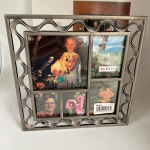 May include: A multi-photo frame with a wavy, silver-colored border. The frame holds four photos of varying sizes. One photo features a child holding a puppy. The frame has the brand name "BURNES" printed on one of the photos.