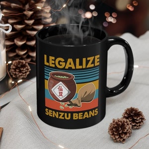 May include: Black coffee mug with a retro design featuring the text "Legalize Senzu Beans" and a cartoon image of a pot of beans with a bag of beans spilling out.