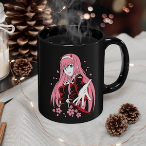 May include: Black ceramic mug with a white image of an anime character with pink hair and a red and white outfit. The character is holding out their hand with pink cherry blossoms in the background.