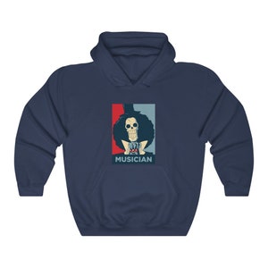 May include: A navy blue hoodie with a graphic of a skeleton character with a top hat and afro, wearing a red bow tie and a blue jacket. The graphic is in a red, white, and blue color scheme and has the word "MUSICIAN" printed below it.