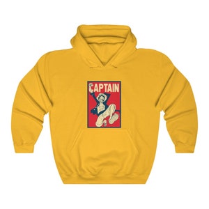 K&ouml;nnte beinhalten: Gelber Hoodie mit einer roten und blauen Grafik eines Comic-Charakters mit dem Wort "CAPTAIN" &uuml;ber dem Charakter.