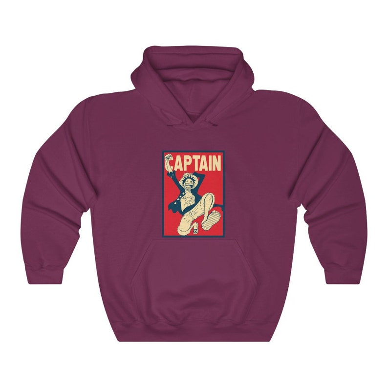K&ouml;nnte beinhalten: Ein maroonfarbener Hoodie mit einem Vintage-Poster-Druck eines Anime-Charakters, der springt, mit dem Wort "CAPTAIN" in wei&szlig; auf rotem Hintergrund.