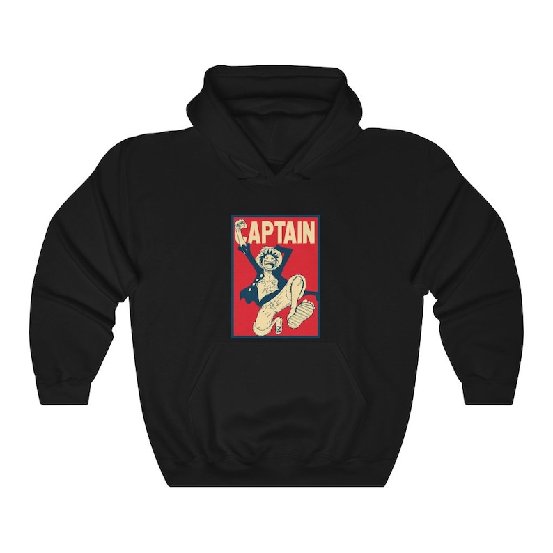 K&ouml;nnte beinhalten: Schwarzer Kapuzenpullover mit einer roten und blauen Grafik eines Anime-Charakters mit dem Wort "CAPTAIN" in wei&szlig;er Schrift.