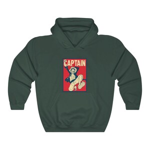 K&ouml;nnte beinhalten: Ein dunkelgr&uuml;ner Kapuzenpullover mit einer roten und wei&szlig;en Grafik eines springenden Comic-Charakters mit dem Wort "CAPTAIN" in wei&szlig;en Buchstaben.