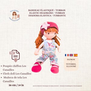 May include: A cloth doll with red hair, wearing a pink hat with a star, and a blue jumpsuit with a ballerina print. The doll is 14 inches tall. Text on the image includes "ELASTIC HEADBAND / TURBAN" and "Cloth doll Les Canailles."