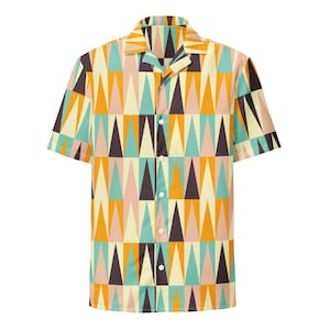 May include: A short-sleeve button-down shirt featuring a repeating geometric pattern of triangles in shades of mustard yellow, teal, dark brown, and pale pink. The shirt has a classic collar, a front button placket with white buttons, and a straight hem.