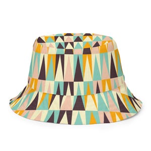 Könnte beinhalten: Ein farbenfroher Fischerhut mit geometrischem Muster. Der Hut zeigt ein sich wiederholendes Design aus Dreiecken in Türkis, Orange, Rosa, Creme und Braun. Ein lässiges Accessoire.