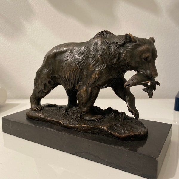 Vintage bronze sculpture of a grizzly bear with fish. Solid bronze art object in antique style.