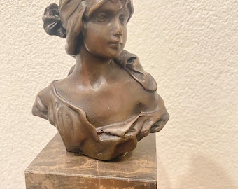 Può includere: Scultura in bronzo di un busto di donna con un panno drappeggiato, su una base di marmo.