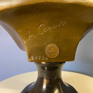 K&ouml;nnte beinhalten: Nahaufnahme einer Bronzeb&uuml;ste mit dunklem, poliertem Sockel. Die B&uuml;ste tr&auml;gt die Inschrift "A. Canova" und einen runden Stempel mit der Aufschrift "GARANTI J.B. DEPOSE PARIS". Die Nummer "46154" ist ebenfalls sichtbar.