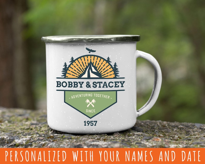 May include: White enamel camping mug with a black rim and handle. The mug features a custom design with the names "BOBBY & STACEY", a mountain, tent, and trees, and the text "ADVENTURING TOGETHER" and "SINCE 1957".