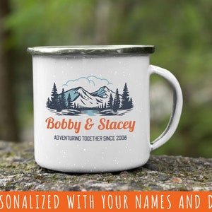 May include: White enamel camping mug with a mountain scene and the text "Bobby & Stacey Adventuring Together Since 2008".