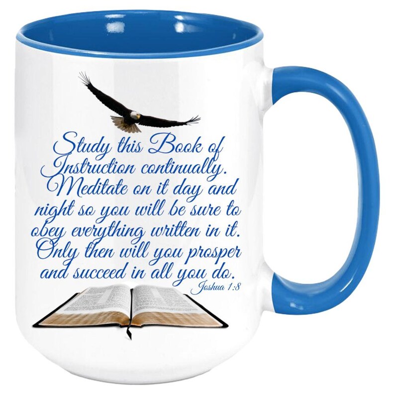 May include: White ceramic coffee mug with a blue rim and handle. The mug features a blue and white illustration of an open bible with a soaring eagle above it. The text reads "Study this Book of Instruction continually. Meditate on it day and night so you will be sure to obey everything written in it. Only then will you prosper and succeed in all you do. Joshua 1:8"