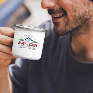 May include: White enamel camping mug with a black rim and a logo that says "Bobby & Stacey" with a mountain range graphic and the text "Adventuring Together Since 1988".