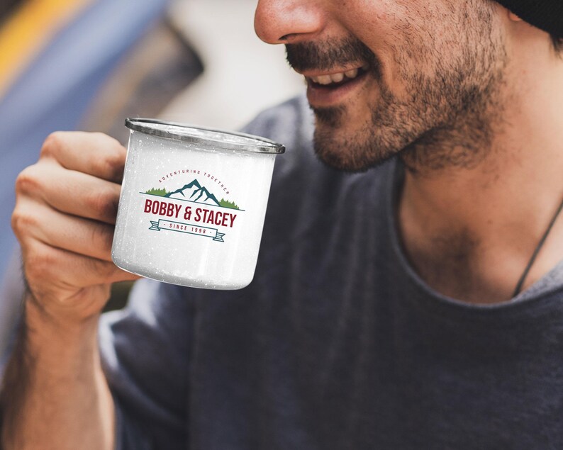 May include: White enamel camping mug with a black rim and a logo that says "Bobby & Stacey" with a mountain range graphic and the text "Adventuring Together Since 1988".