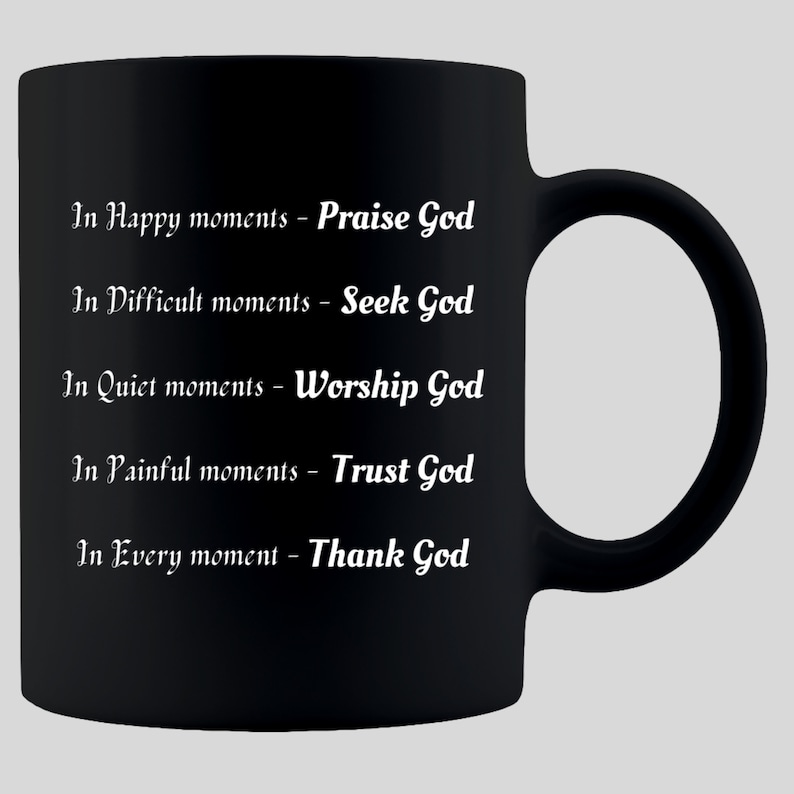 May include: Black ceramic mug with white text. The text reads: "In Happy moments - Praise God, In Difficult moments - Seek God, In Quiet moments - Worship God, In Painful moments - Trust God, In Every moment - Thank God."