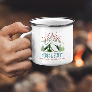 May include: White enamel camping mug with a red, green, and blue mountain scene and a tent. The text "BOBBY & STACEY - ADVENTURING TOGETHER SINCE 2014 -" is printed on the mug.
