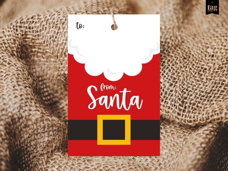 May include: A rectangular gift tag with a Santa Claus design. The tag features a red background with a white cloud-like shape at the top and a black belt with a gold buckle. The words "from: Santa" are written in white script.